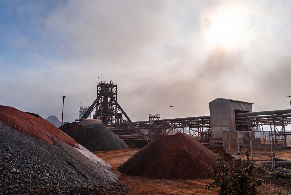 Copper mining facility with large ore stockpiles and processing towers